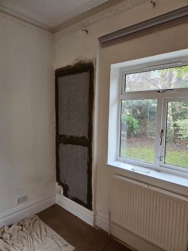 Peeling plaster on a wall with uneven surfaces and exposed sections.